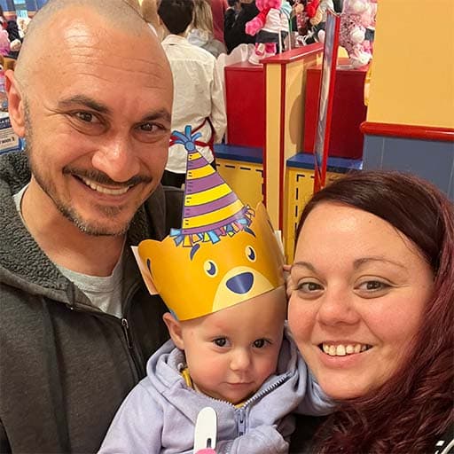 Chris smiling and holding his daughter